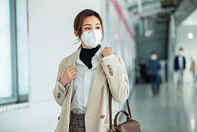 戴口罩的年轻女人走在地铁站