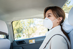 年轻女人戴口罩乘坐汽车图片