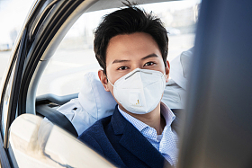 年轻男人戴口罩乘坐汽车