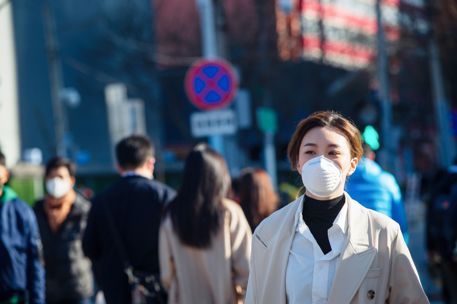 青年女人戴口罩在户外行走图片