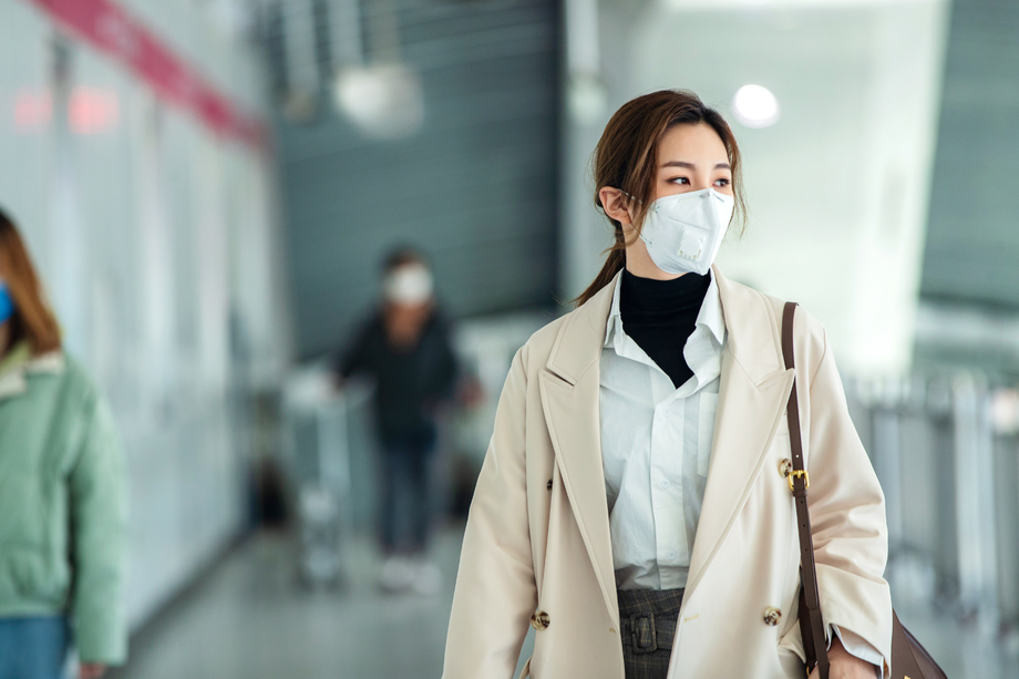 戴口罩的年轻女人走在地铁站