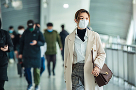戴口罩的年轻女人走在地铁站