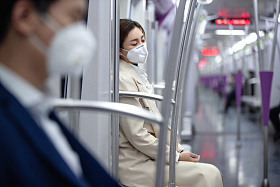 年轻女人戴口罩坐地