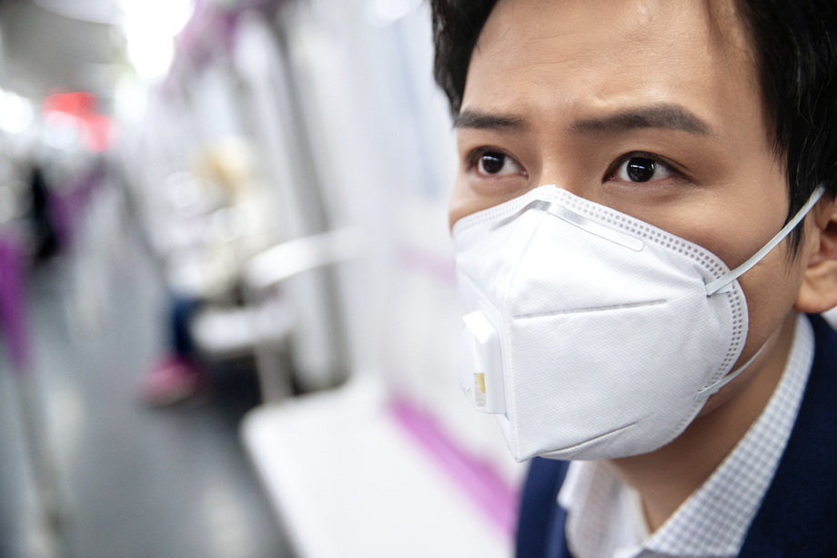 青年男子戴口罩乘坐地铁图片