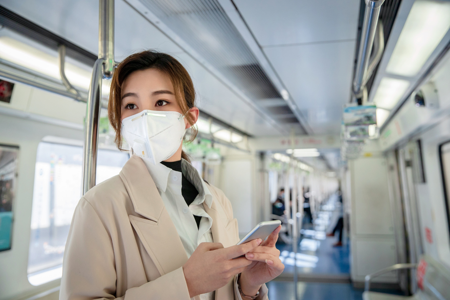 戴口罩的年轻女人站在地铁里照片