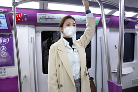 戴口罩的年轻女人乘坐地
