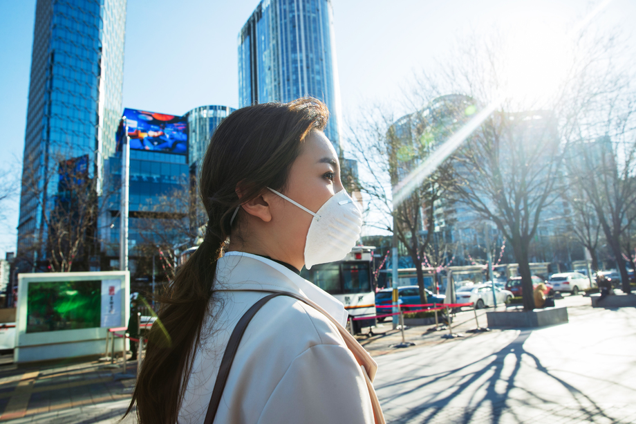 青年女人戴口罩在户外行走图片