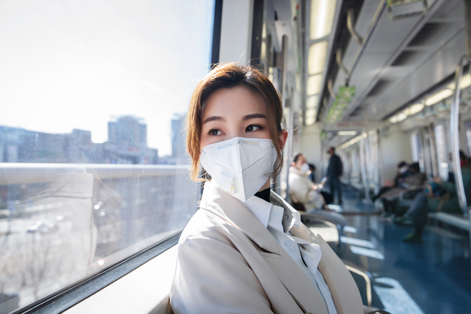 戴口罩的年轻女人乘坐地 戴口罩的年轻女人乘坐地