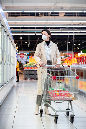 戴口罩的青年女人在超市购物图片