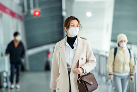 戴口罩的年轻女人走在地铁站