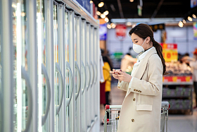 戴口罩的青年女人在超市购物图片