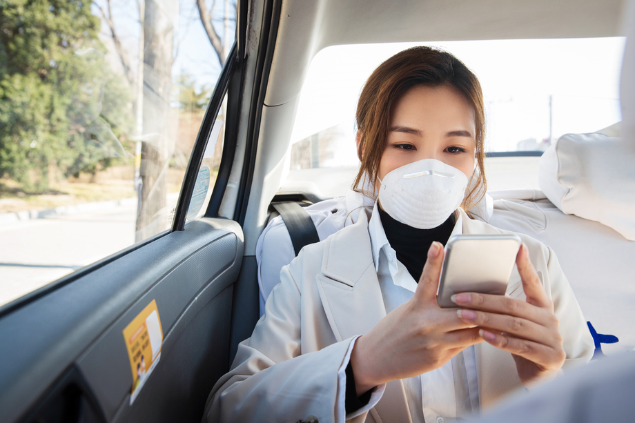 年轻女人戴口罩乘坐汽车