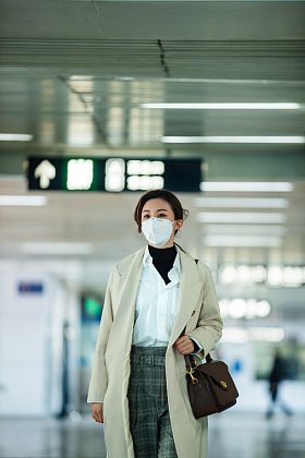 戴口罩的年轻女人走在地铁站
