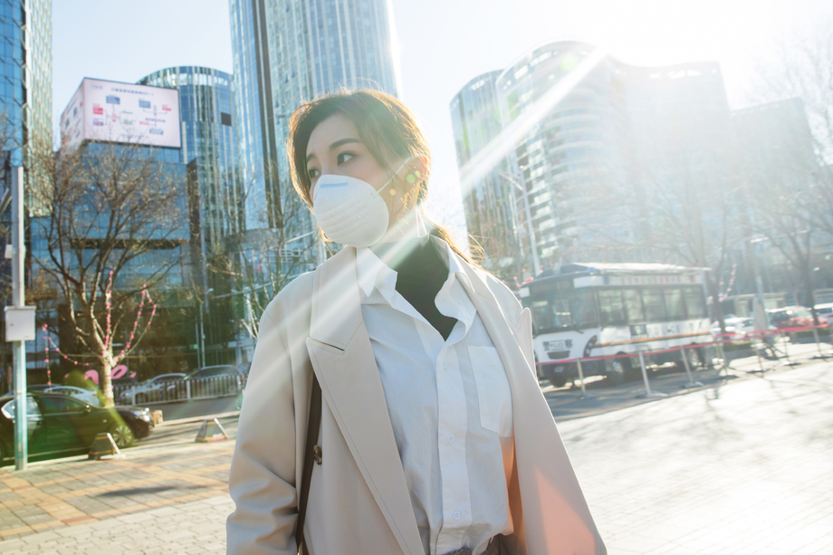 青年女人戴口罩在户外行走图片