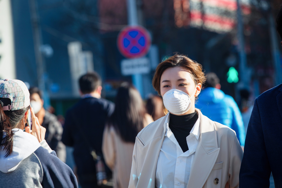 青年女人戴口罩在户外行走图片
