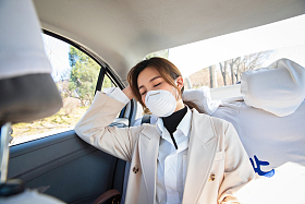 年轻女人戴口罩乘坐汽车图片