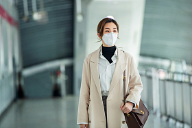 戴口罩的年轻女人走在地铁站