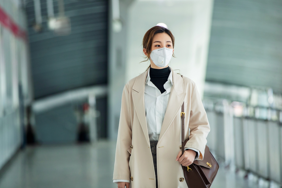 戴口罩的年轻女人走在地铁站
