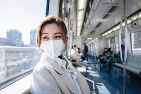 戴口罩的年轻女人乘坐地