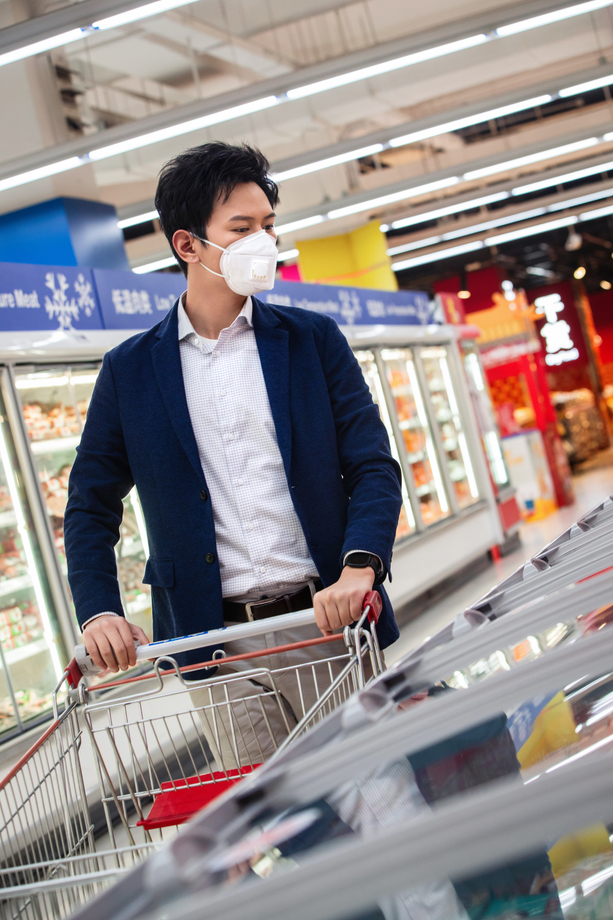 戴口罩的青年男人在超市购物图片