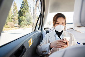 年轻女人戴口罩乘坐汽车图片