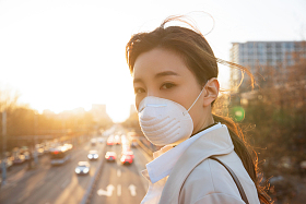 青年女人戴口罩在户外行走照片