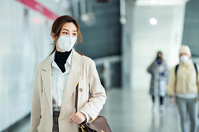 戴口罩的年轻女人走在地铁站