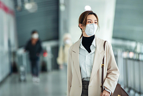 戴口罩的年轻女人走在地铁站