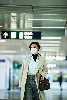 戴口罩的年轻女人走在地铁站