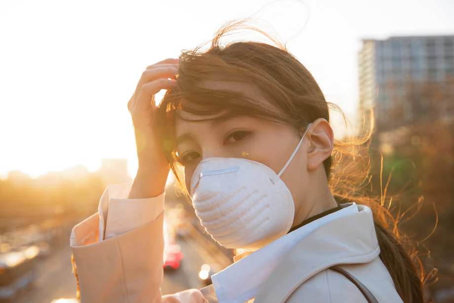 青年女人戴口罩在户外行走