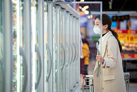 戴口罩的青年女人在超市购物图片