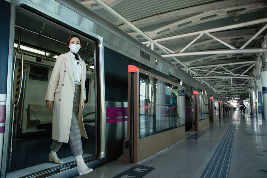 戴口罩的年轻女人出地铁照片 戴口罩的年轻女人出地铁照片