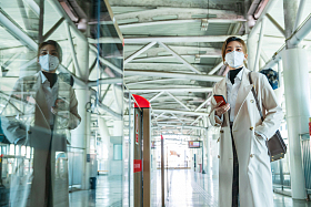 戴口罩的年轻女人站在地铁站台上