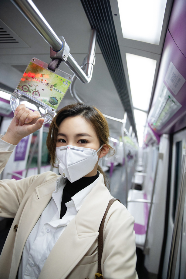 戴口罩的年轻女人乘坐地