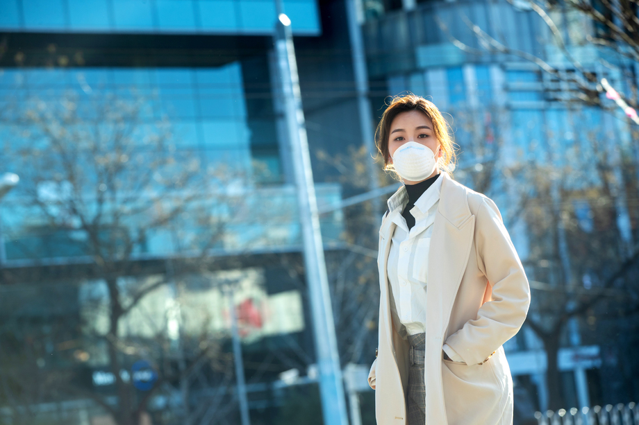 青年女人戴口罩在户外行走图片