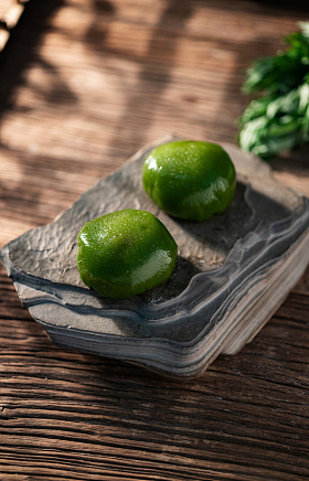 木桌上岩石盘里的青团