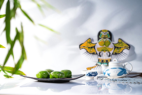 竹叶旁的风筝茶具和青团图片