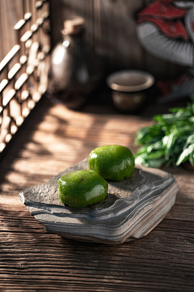 木桌上岩石盘里的青团图片