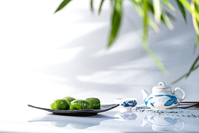 竹叶下的青团和茶具照片