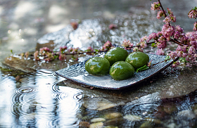 水面石板上的青团和桃花照片