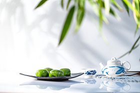 竹叶下的青团和茶具图片