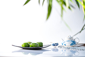 竹叶下的青团和茶具图片