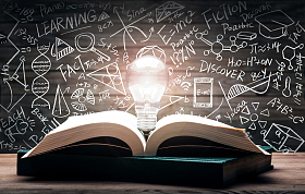 黑板画前打开的书和发光的灯泡