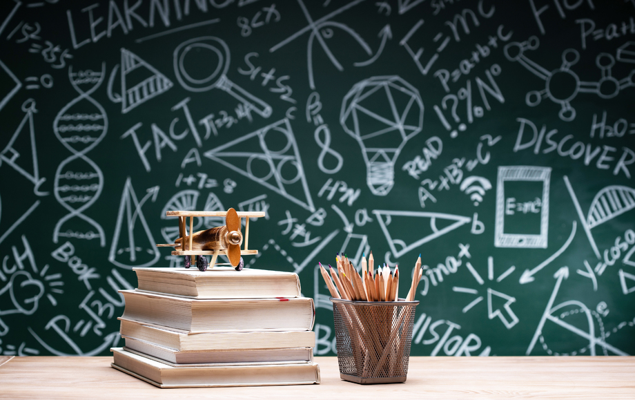 黑板画前桌子上的学习用品和飞机模型 黑板画前桌子上的学习用品和飞机模型