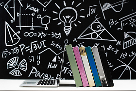 黑板画前的桌子上的书和笔记本电脑