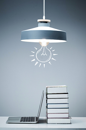 吊灯下的书和笔记本电脑照片