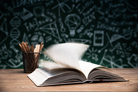 黑板画前的桌子上摊开的书