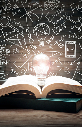 黑板画前打开的书和发光的灯泡