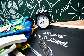 黑板前的桌子上堆满了学习用