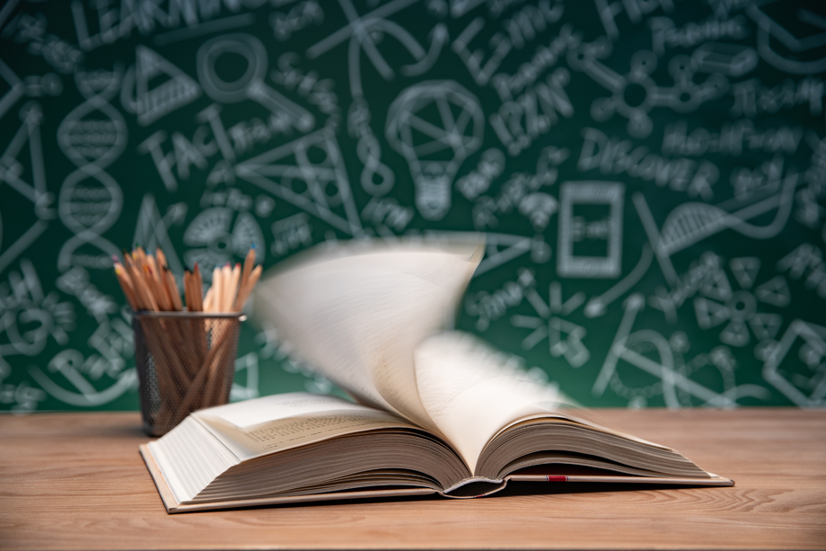 黑板画前的桌子上打开的书和笔筒 黑板画前的桌子上打开的书和笔筒